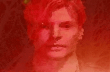 a close up of a man 's face in a red light .