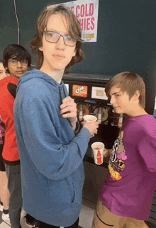 a group of young boys are standing in front of a machine that says " cold fries "