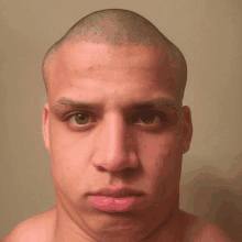 a man with a shaved head looks at the camera with a serious look on his face