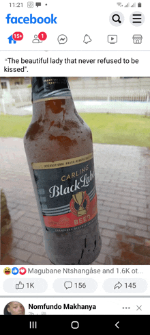 a bottle of carling black label beer sits on a brick sidewalk