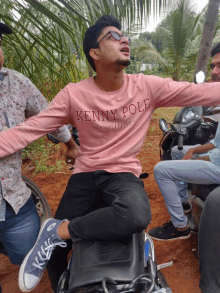 a man wearing a pink kenny pole originals shirt