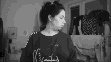 a black and white photo of a woman wearing a sweater that says ' i 'm tired ' on it .