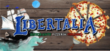 a sign for libertalia ristorante pizzeria italiano with a pizza on a wooden table