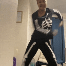 a woman in a skeleton costume is dancing in a room