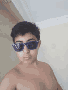 a young boy is taking a selfie while wearing sunglasses .