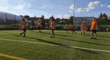 a group of young men are playing soccer on a field and one of them is wearing an orange shirt with the number 23