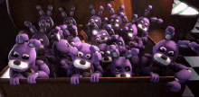 a bunch of purple stuffed animals are peeking out of a wooden box