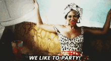 a woman in a leopard print dress is sitting on a couch saying we like to party