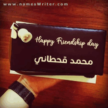 a person holding a cake that says happy friendship day on it