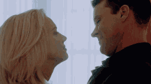 a man and a woman are looking at each other and smiling