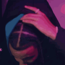 a person wearing a hooded jacket with a cross on it