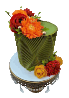 a green cake with flowers on top has the initials a.e.c. on it