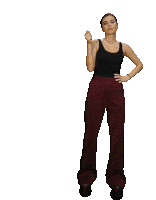 a woman in a black tank top and maroon pants is dancing