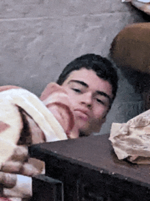 a man laying on a table with a piece of bread on his head