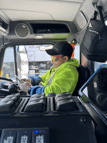 a man in a yellow vest is driving a truck