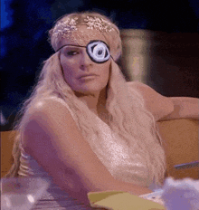 a woman wearing an eye patch and a headpiece