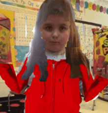 a girl in a red jacket is standing in front of a classroom with a bag of snickers on the wall