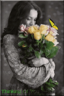 a black and white photo of a woman holding a bouquet of flowers with the words thinking of you on the bottom