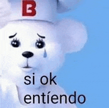 a white teddy bear wearing a hat with the letter b on it is crying and saying `` si ok entiendo '' .