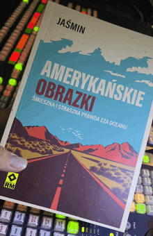 a book titled amerykańskie obrazki by jasmin is being held in someone 's hand