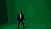 a man in a suit dancing on a green screen