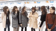 a group of women are standing in front of a check in counter with a sign that says ' tokyo ' on it