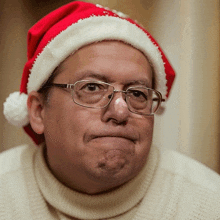 a man wearing glasses and a santa hat makes a face