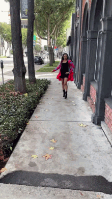 a woman walking down a sidewalk in front of a building that has a sign that says ' pacific '