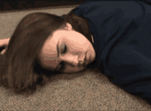 a woman is laying on the floor with her head down .