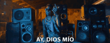 a man stands in front of a stack of speakers with the words ay dios mio written below him