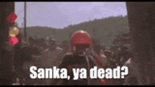 a man in a red helmet is standing in front of a crowd and says `` anka , ya dead ? ''