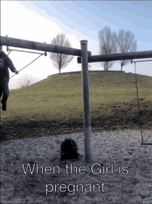 a man swings on a swing set with the words when the girl is pregnant below him