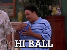 a man in a blue shirt is holding a ball with the words hi ball written on it