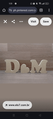 a phone screen shows a picture of a wooden letter d and m