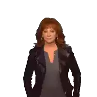 a woman with red hair is wearing a black leather jacket and a grey shirt