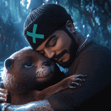 a man wearing a black hat with a green cross on it is hugging a stuffed animal