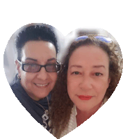 two women are posing for a picture in a heart shape