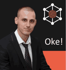 a man in a suit and tie stands in front of a sign that says oke on it