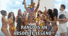 a group of women in bikinis are standing around a man in a cowboy hat with the caption rango is an absolute legend !