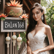 a woman in a white dress stands in front of a sign for balon 168