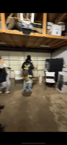 a blurry photo of people in a garage with a man wearing a shirt that says ' eagle ' on it