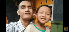 a man and a boy are posing for a picture together and smiling .