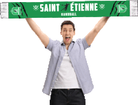 a man holds up a green scarf with saint etienne handball written on it