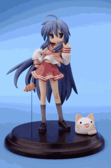 a figurine of a girl with blue hair and a red skirt