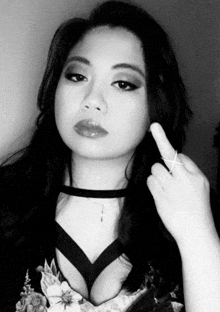 a woman wearing a choker and a ring giving the middle finger