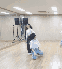 a group of women are dancing in a dance studio in front of a large mirror .