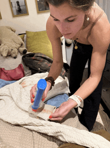 a woman is cleaning a sweater with a blue bottle that says ' cleaning ' on it