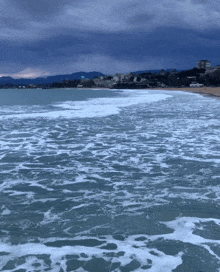 a large body of water with waves crashing on the beach