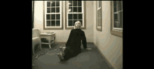 a woman in a black dress is sitting on the floor in a room