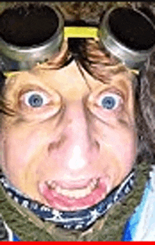 a close up of a person 's face wearing goggles and a scarf .